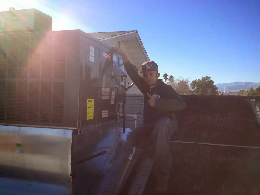 HVAC technician performing HVAC Inspection on a rooftop unit in Evans